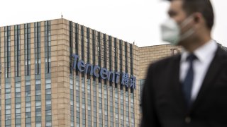 Signage for Tencent Holdings atop an office building in Shanghai, China, on March 22, 2022. China’s Tencent reported on Wednesday its quarterly profit halved from a year ago and revenues stagnated, blaming cuts in advertising spending by consumer, e-commerce and travel businesses for its worst performance since it went public in 2004.