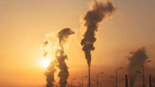 A smokestack against an orange sky