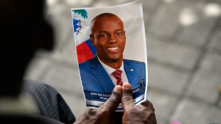 FILE - A person holds a photo of late Haitian President Jovenel Moise during his memorial ceremony at the National Pantheon Museum in Port-au-Prince, Haiti, July 20, 2021. Authorities say a former Haitian senator is facing charges in the United States related to Moise’s assassination. Court records show that John Joel Joseph made his initial appearance Monday, May 9, 2022, in Miami federal court.
