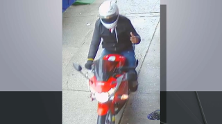 Necklace thief rides motorcycle in surveillance image.