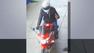 Necklace thief rides motorcycle in surveillance image.