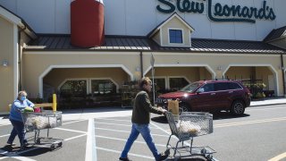 Customers push shopping carts outside a Stew Leonard’s supermarket in Paramus, New Jersey, U.S., on Tuesday, May 12, 2020. Stew Leonard Jr. said that meat packing plant the company uses is operating at about 70 percent capacity, and he expects it to rebound to full capacity in about a month, CT Post reported.