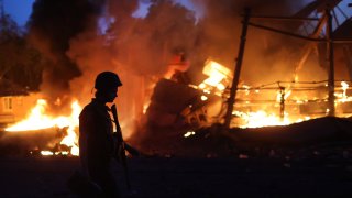 Flames rise from a structure after it was hit by projectile on June 20, 2022 in Druzhkivka, Ukraine. In recent weeks, Russia has concentrated its firepower on Ukraine’s Donbas region, where it has long backed two separatist regions at war with the Ukrainian government since 2014.