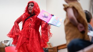 A drag queen who goes by the name Flame reads stories to children and their caretakers during a Drag Story Hour at a public library in New York, Friday, June 17, 2022.