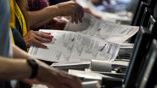 Election workers perform a recount of ballots