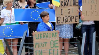 Protestors in support of Ukraine stand with signs and EU flags during a demonstration outside of an EU summit in Brussels, Thursday, June 23, 2022.