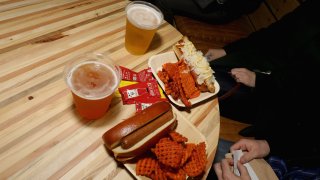 People sit at a table preparing to eat their food.