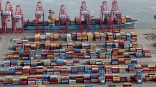Shipping containers are unloaded from a ship at a container terminal at the Port of Long Beach-Port of Los Angeles complex, in Los Angeles, California, April 7, 2021.