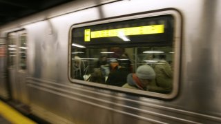 A Queens bound F train rolls into a subway station