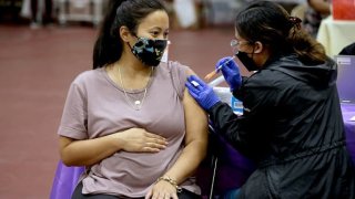 A woman receives a Pfizer vaccination booster shot at Eugene A. Obregon Park in Los Angeles.