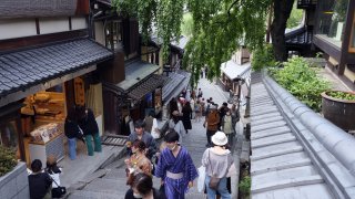 Visitors walk on the Sannenzaka slope in Kyoto, Japan. Travel stocks in Japan rose on reports that border measures may be eased further.