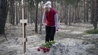 Ukrainian woman Lyudmila Trekushenko mourns on the graveside of her deceased husband, who died in a Russian attack, in Izium city after Russian Forces withdrawal in, Kharkiv Oblast, Ukraine on September 19, 2022.