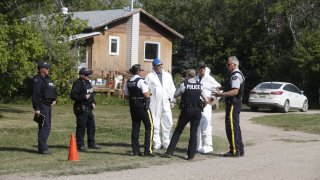 Royal Canadian Mounted Police forensics officers speak outside the crime scene where stabbing victim Wes Petterson was found, in Weldon, Saskatchewan, Canada, on September 7, 2022.