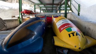 Bobsleds are parked next to the track in Cortina d’Ampezzo, Italy, on Feb. 17, 2021.