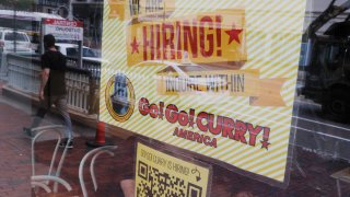 The Go! Go! Curry restaurant has a sign in the window reading “We Are Hiring” in Cambridge, Massachusetts, July 8, 2022.