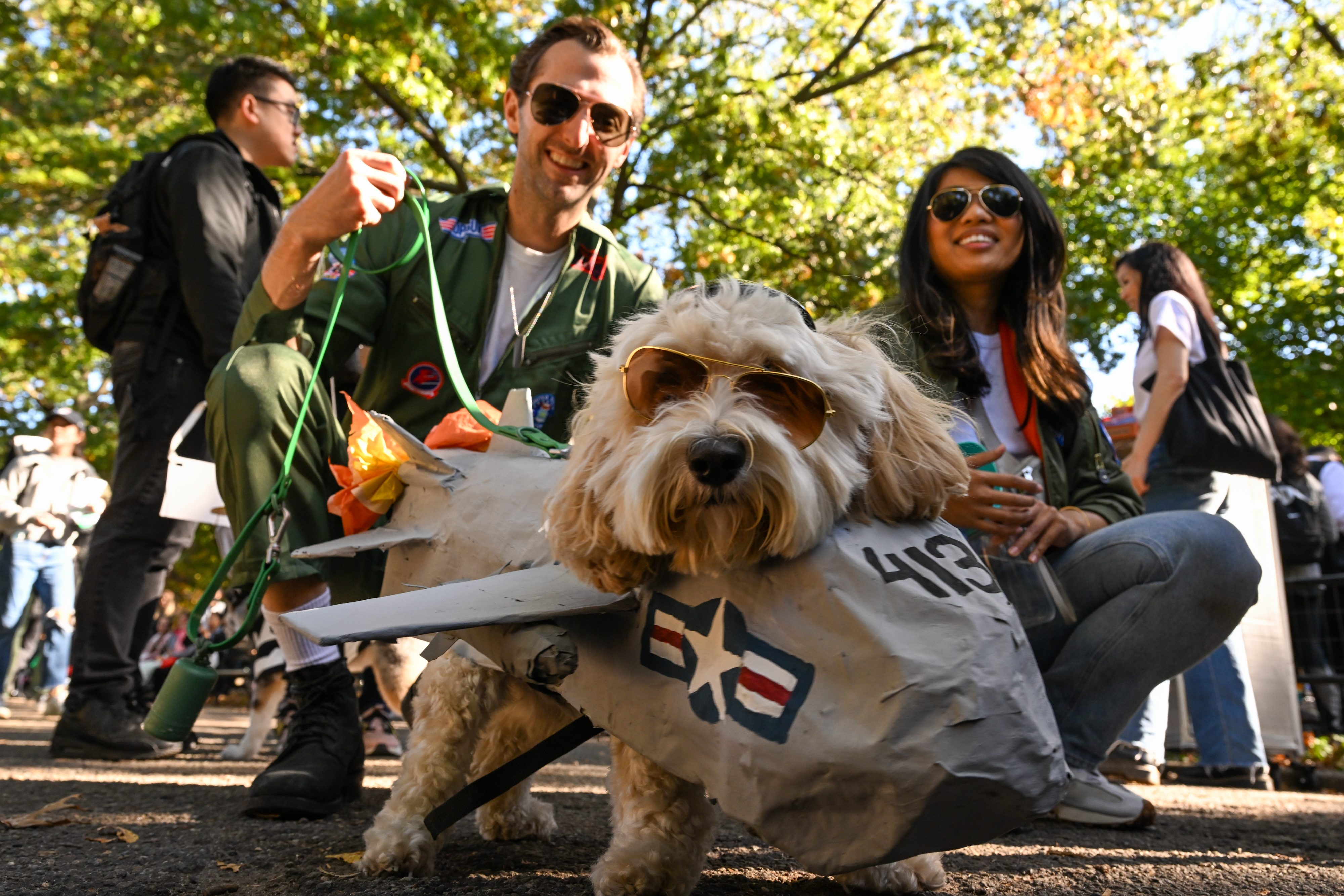 Aaron Reeves and Farah Azmi with their cockapoo, Theo, dressed as Top Gun: Maverick. (Photo by Alexi Rosenfeld/Getty Images)