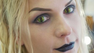Woman with halloween makeup and snake contacts.