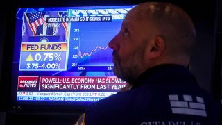 A trader watches as Federal Reserve Chair Jerome Powell speaks on a screen on the floor of the New York Stock Exchange (NYSE), November 2, 2022.
