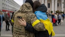 A woman hugs a Ukrainian soldier as local residents gather to celebrate the liberation of Kherson, on November 13, 2022, amid Russia's invasion of Ukraine.