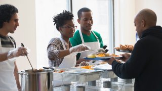 Volunteers serving food in cafeteria