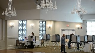 People vote at the Crystal Ballroom in New Britain, Conn.