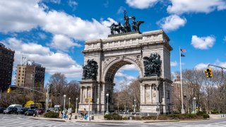 The Grand Army plaza archway in Brooklyn, New York commemorating the first battle of the American war of Independence. Now surrounded by a busy traffic circle with tourists on rental bikes on sunny day.