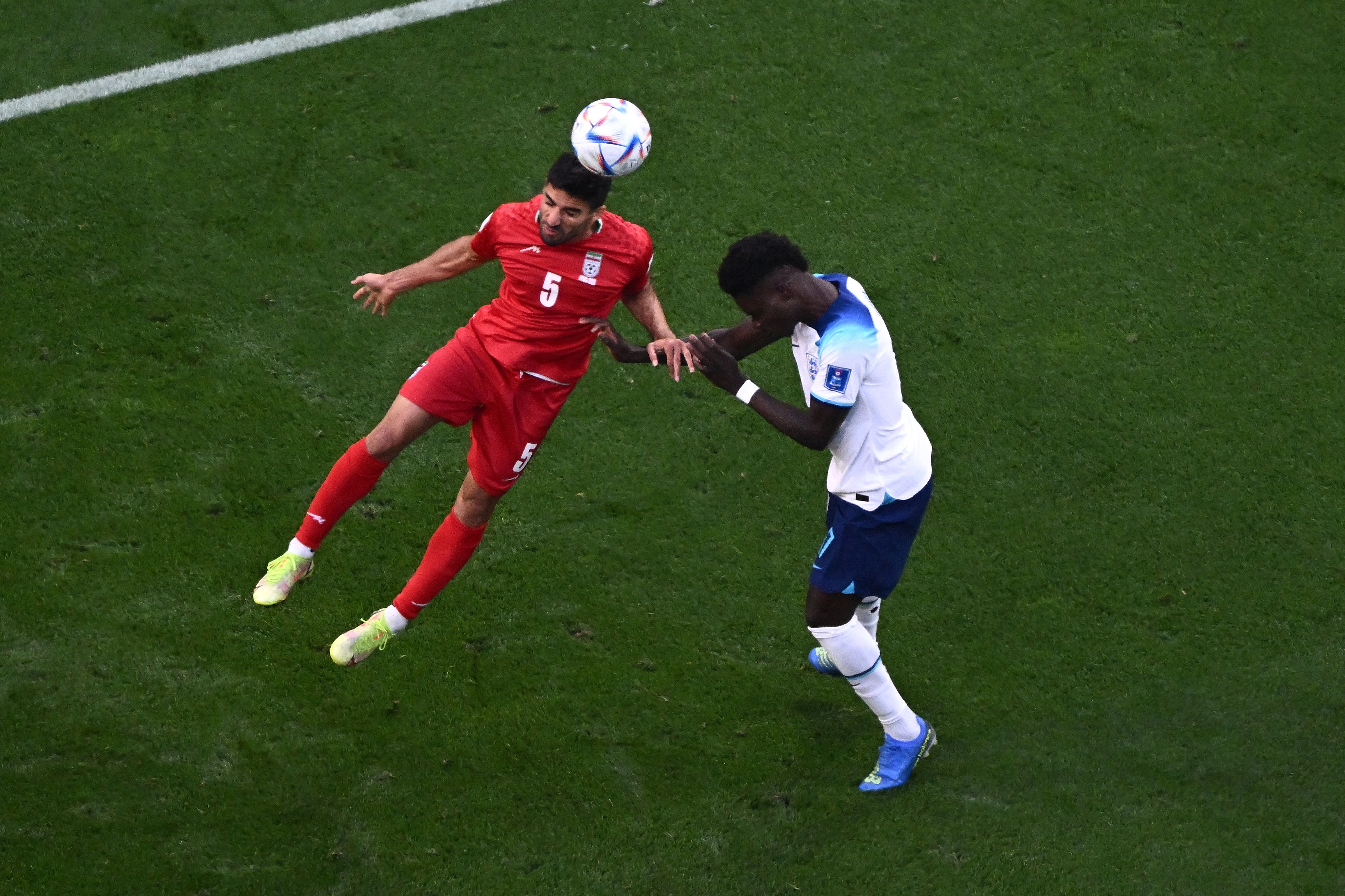 Iran’s defender #5 Milad Mohammadi, left, heads the ball during the Qatar 2022 World Cup Group B football match between England and Iran at the Khalifa International Stadium in Doha, Nov. 21, 2022.