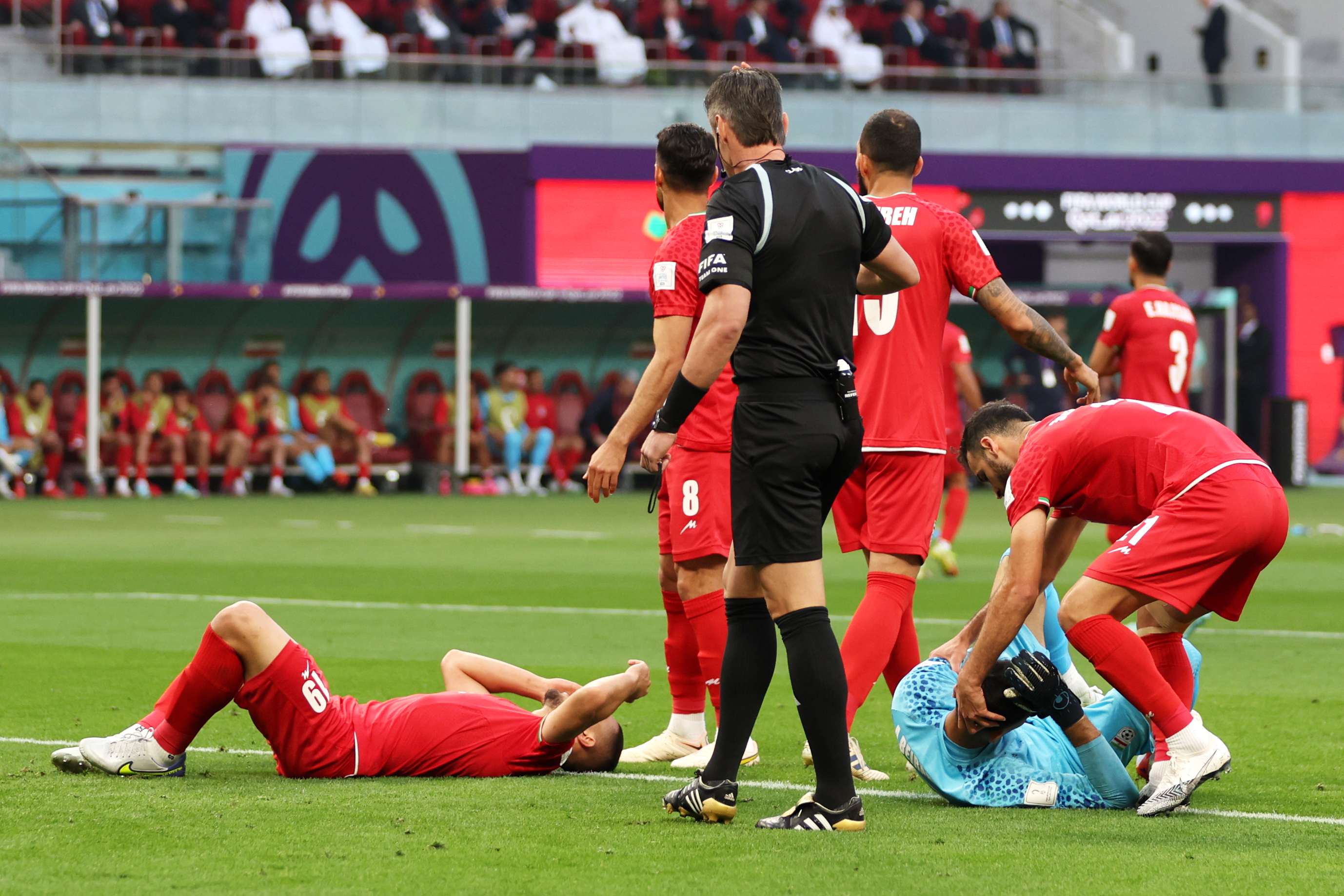 Majid Hosseini and Payam Niazmand of IR Iran lie on the ground after colliding during the FIFA World Cup Qatar 2022 Group B match between England and IR Iran at Khalifa International Stadium on Nov. 21, 2022, in Doha, Qatar.