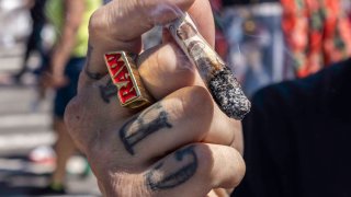 A man smokes marijuana during a hip-hop performance at the 11th annual block party held by the Bushwick Collective in Brooklyn, New York, on June 4, 2022.