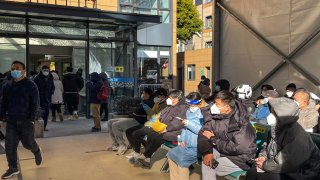 People wait outside a fever clinic at Tongren Hospital in Shanghai on Dec. 23, 2022, amid a local outbreak of Covid-19 infections.