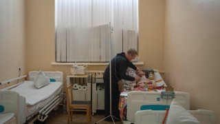 Serhii Shumei, 64, talks to his son Vitalii, 34, a Ukrainian officer wounded in a battle with Russian forces, in a city hospital in Chernihiv, Ukraine, Wednesday, Jan. 11, 2023.