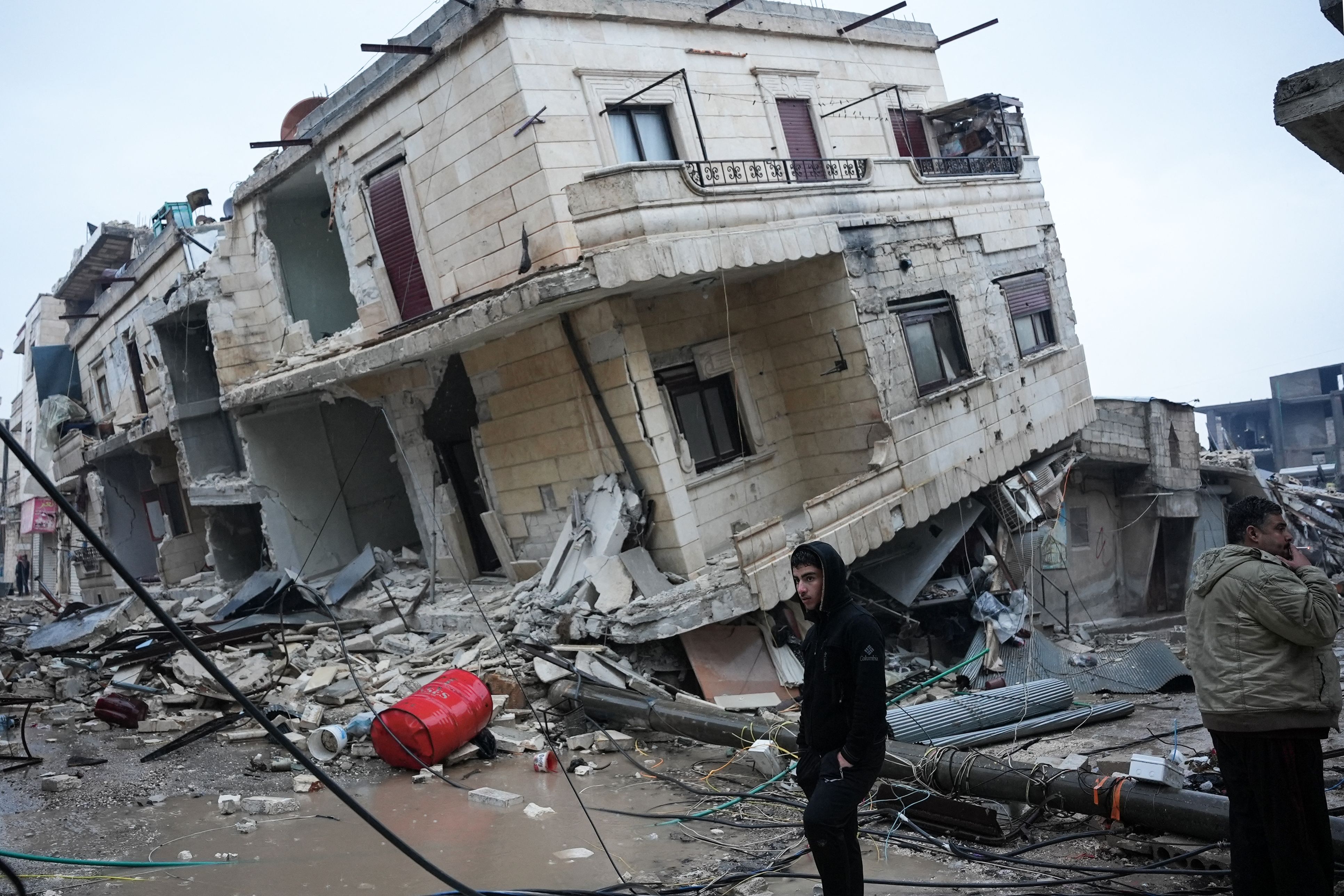 Residents stand in front of a collapsed building in Jindires, Syria, Feb. 6, 2023, after a 7.8-magnitude earthquake hit the border of Turkey and Syria.