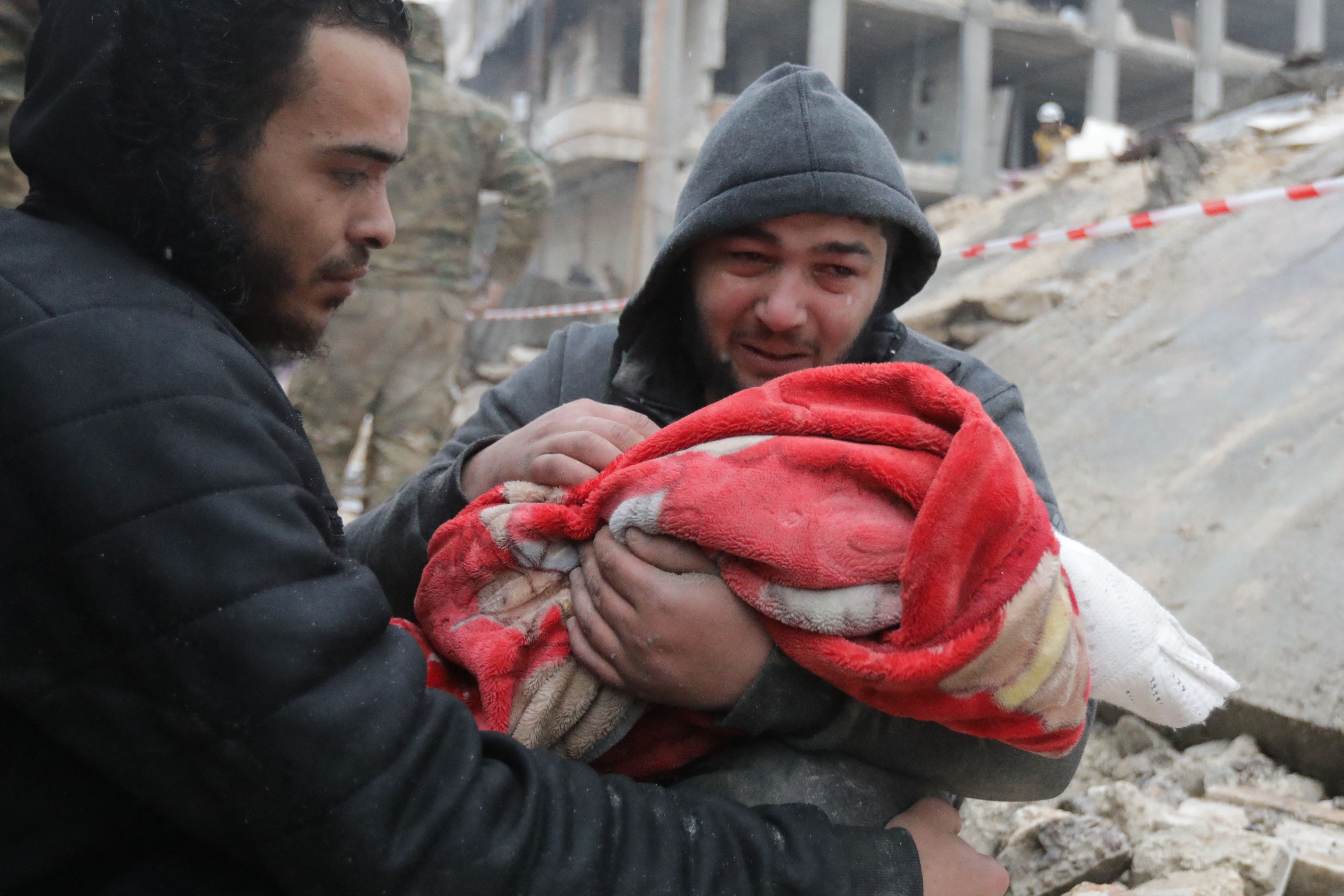 A Syrian man weeps as he carries the body of his son who was killed in an earthquake in the town of Jindires, Syria, Feb. 6, 2023.