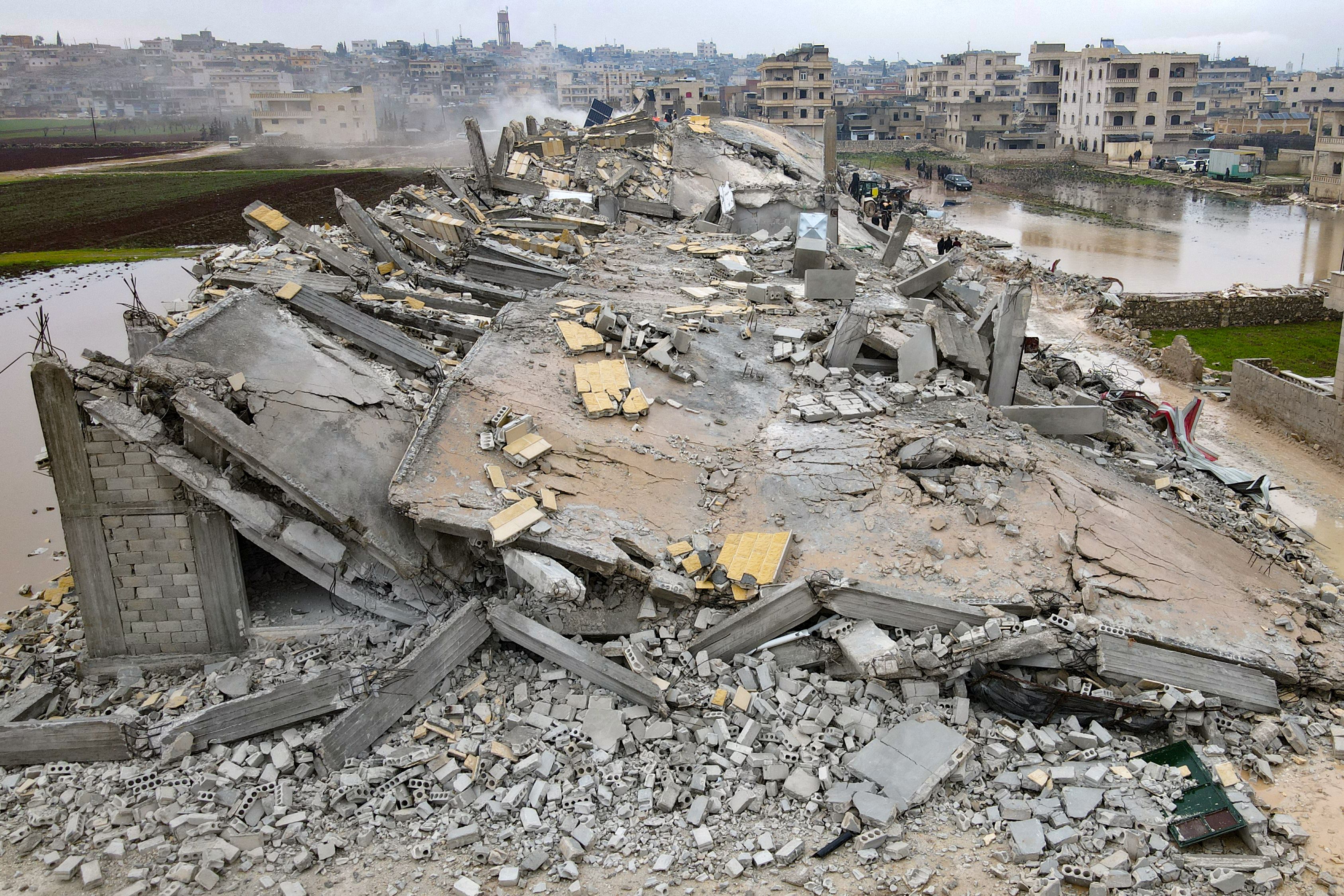 Residents for victims and survivors in the rubble of collapsed buildings, following an 7.8 magnitude earthquake in Sarmada, Syria, Feb. 6, 2023.