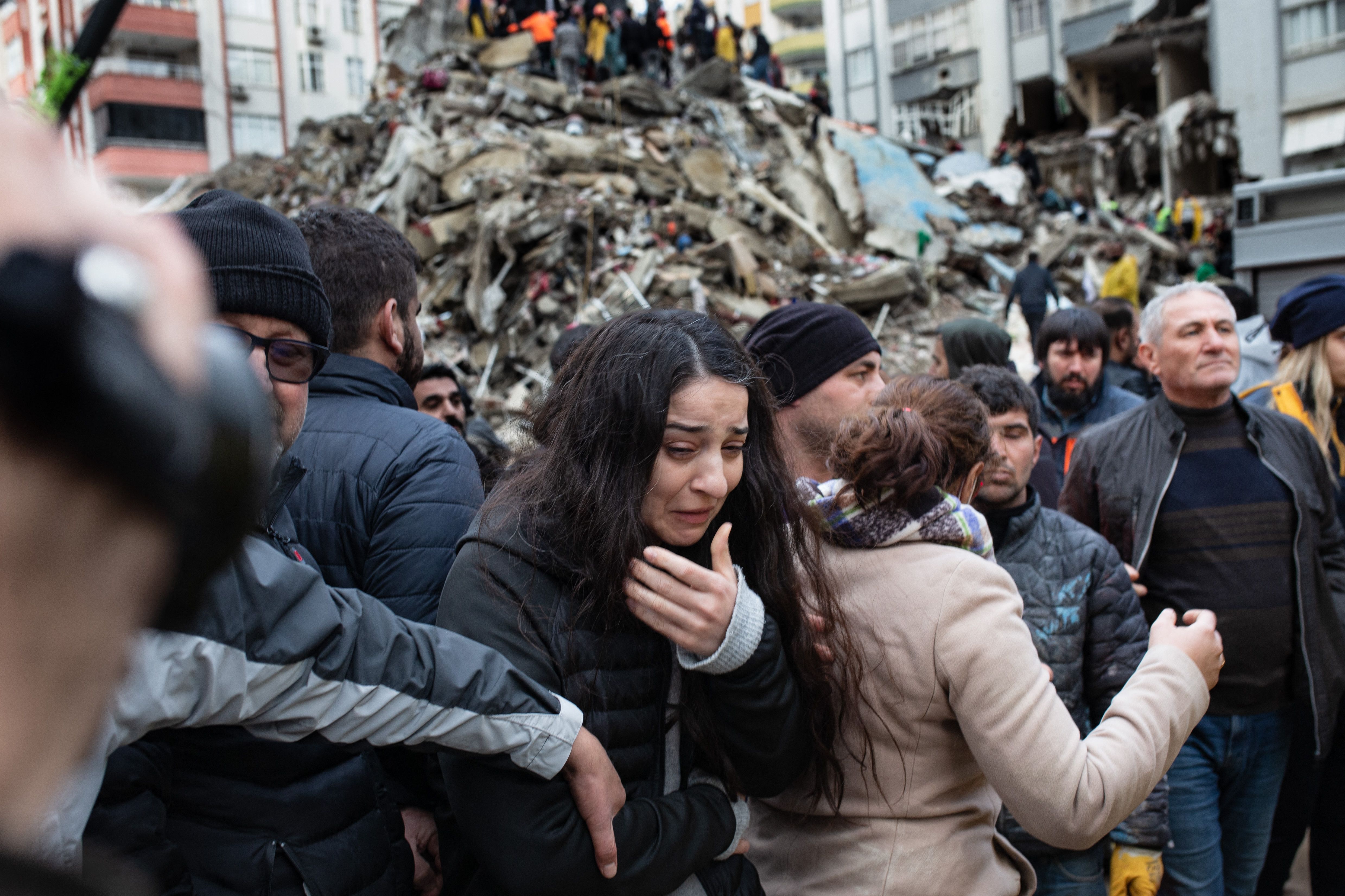 A woman cries as rescuers search for survivors through the rubble of a building that collapsed in Adana, Turkey, Feb. 6, 2023, after a 7.8-magnitude earthquake struck the country’s southeastern border with Syria.