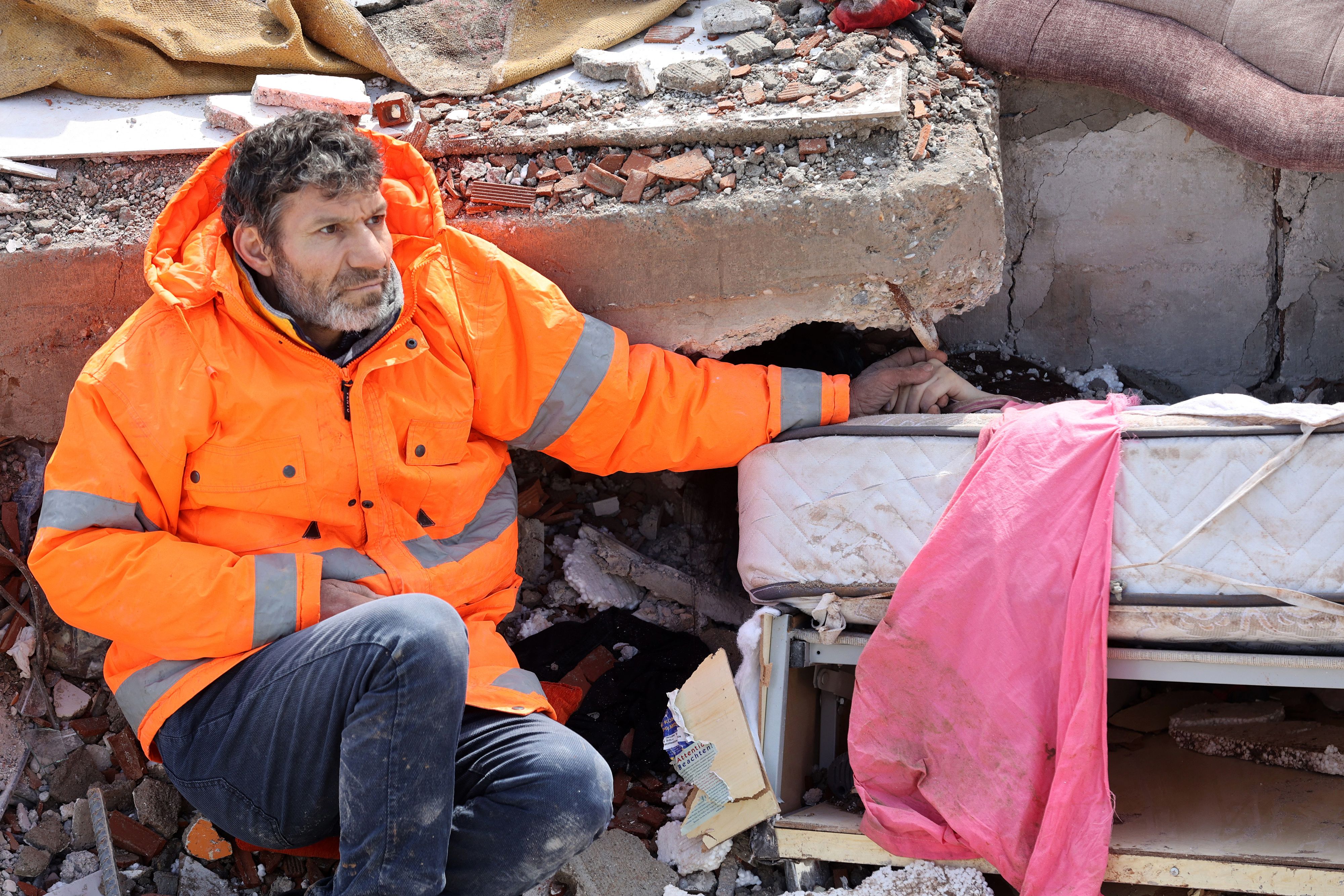 Mesut Hancer holds the hand of his 15-year-old daughter Irmak in Kahramanmaras, Turkey, Feb. 7, 2023. Irmak died when a 7.8-magnitude earthquake struck Turkey’s southeast border with Syria, devastating the region. Kahramanmaras is close to the quake’s epicenter in Gaziantep.