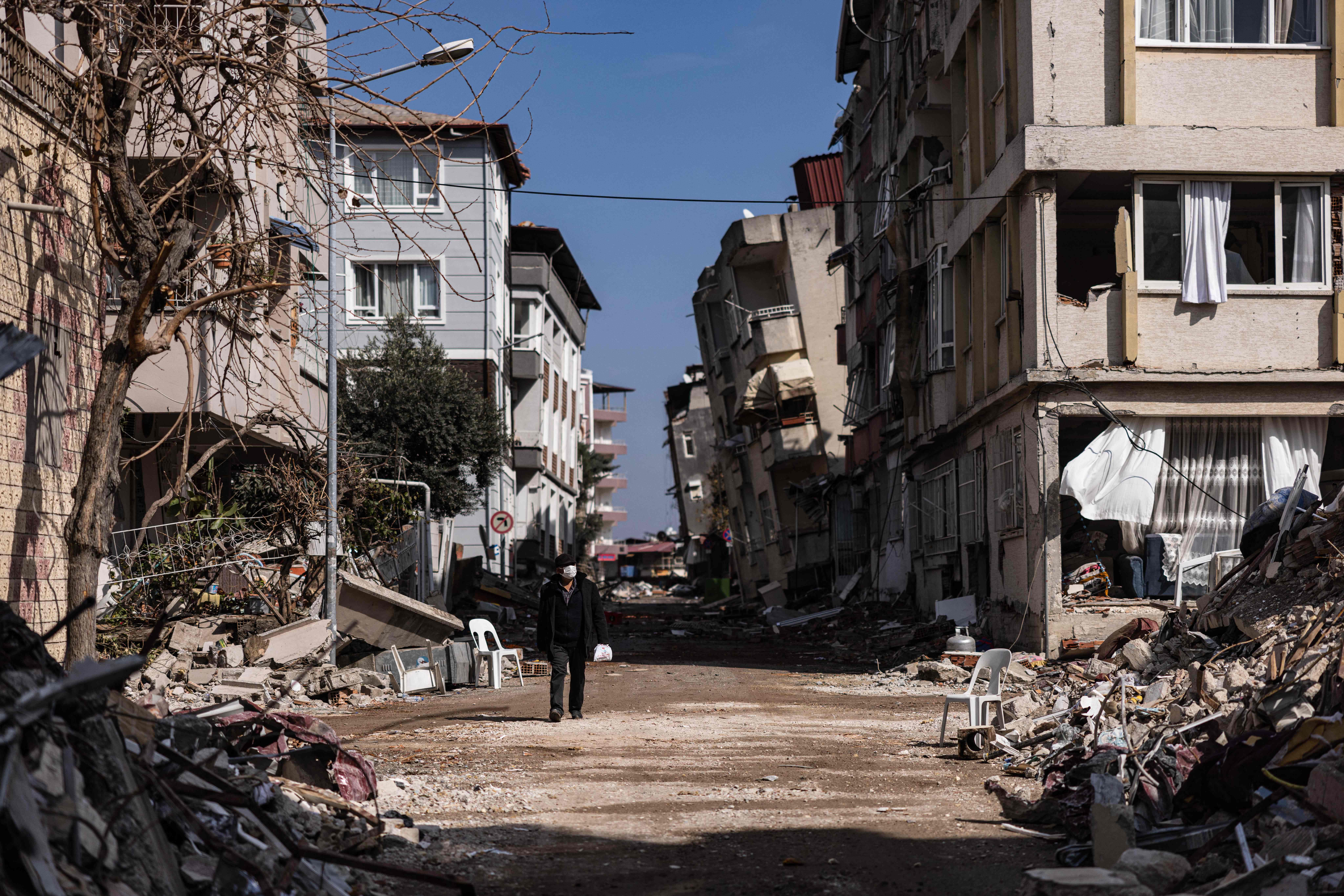 Kahraman, 62, walks past  a row of collapsed buildings after a 6.4-magnitude earthquake hit the Hatay province in southern Turkey, Antakya, Feb. 21, 2023. The 6.4-magnitude earthquake struck on February 20, two weeks after a 7.8-magnitude quake hit near Gaziantep, Turkey, in the early hours of February 6.