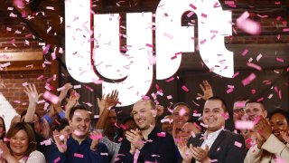 Confetti falls as Lyft CEO Logan Green (C) and President John Zimmer (LEFT C) ring the Nasdaq opening bell celebrating the company’s initial public offering (IPO) on March 29, 2019 in Los Angeles, California. The ride hailing app company’s shares were initially priced at $72.