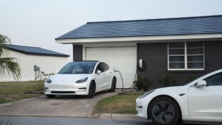 Tesla vehicles parked outside a home with a Tesla Solar Roof on Weems Street in Boca Chica Village, Texas, U.S., on Monday, June 21, 2021.