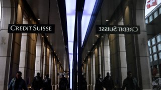 Switzerland’s second largest bank Credit Suisse is seen here next to a Swiss flag in downtown Geneva.