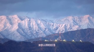 The Hollywood sign stands in front of snow-covered mountains after another winter storm hit Southern California on March 01, 2023 in Los Angeles, California.