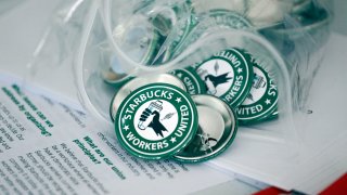 Pro-union pins sit on a table during a watch party for Starbucks’ employees union election, Dec. 9, 2021, in Buffalo, N.Y.
