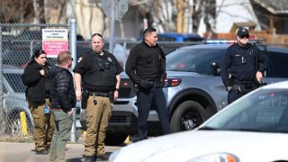 Police officers secures students parking area of Denver’s East High School after a shooting at the school on Wednesday, March 22, 2023.