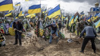 Gravediggers bury the body of serviceman Anatoliy Yalovskyi, who died at the age of 38 during his funeral ceremony in Kyiv, Ukraine on March 27, 2023.