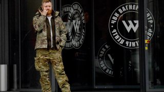 A man wearing military camouflage stands at the entrance of the ‘PMC Wagner Centre’, associated with the founder of the Wagner private military group (PMC) Yevgeny Prigozhin, during the official opening of the office block on the National Unity Day, in Saint Petersburg, on November 4, 2022. 