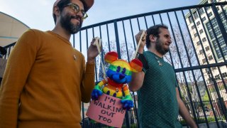 LGBTQ employees Carlos Lopez Estrada , left, and Juan Pablo Reyes holding a Mickey Mouse in rainbow colors, walkout of Disney Animation protesting former CEO Bob Chapek’s handling of the staff controversy over Florida’s “Don’t Say Gay” bill, aka the “Parental Rights in Education” bill, on Tuesday, March 22, 2022 in Burbank, CA.