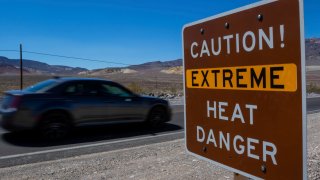 A sign stands warning of extreme heat in Death Valley National Park