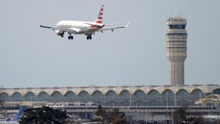 An American Airlines Embraer ERJ-190AR airplane flies past the tower where air traffic controllers work despite not receiving their paycheck, at Reagan National Airport in Washington, January 12, 2019.