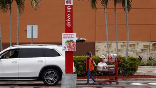 A worker delivers an order to a drive-up customer at a Target store in Miami, Florida, Aug. 19, 2020.