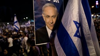 A woman holds a placard with a photo of Israeli Prime Minister Binyamin Netanyahu as the right wing holds a rally to support the government’s judicial overhaul on July 23, 2023 in Tel Aviv, Israel.